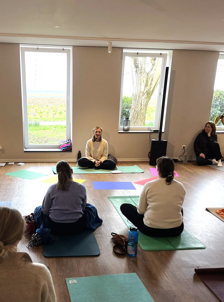 Steffi leitet einen Workshop im Kreis auf Yogamatten